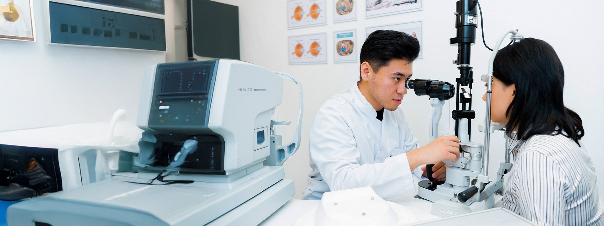A healthcare professional conducts an eye examination for a patient using a slit lamp in a clinical setting.