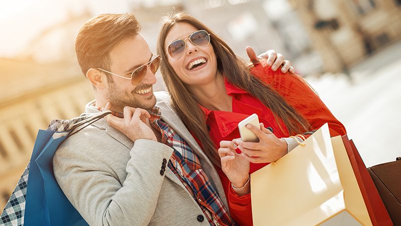 Laughing man and woman with shopping bags