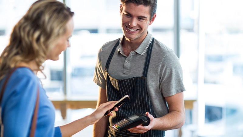 A woman paying contactless with her smartphone