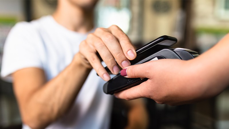 A man paying contactless with his smartphone