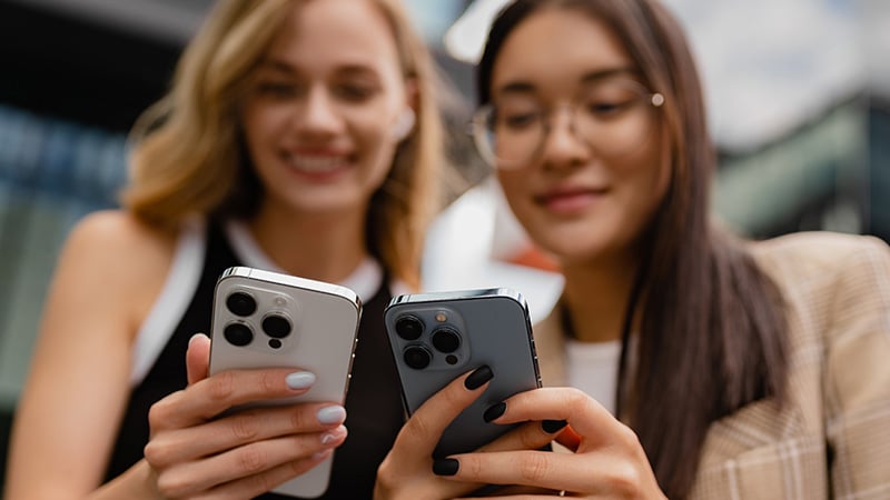 Women using an iPhone with a smile