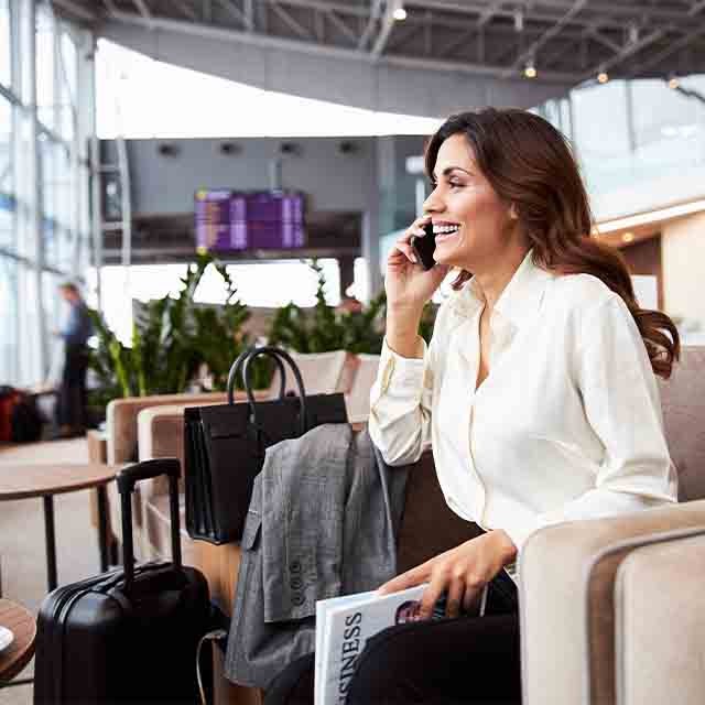 A woman in the airport lounge zone talking on the phone