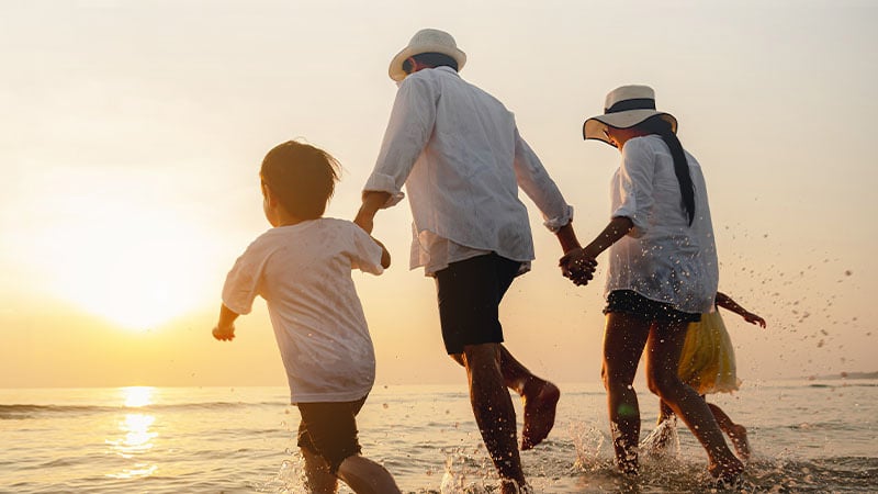 A man, woman, and two children on the sunset beach