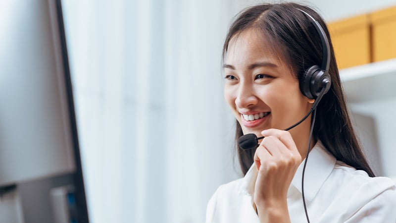 A smiling Kazakh woman with a headset on her head